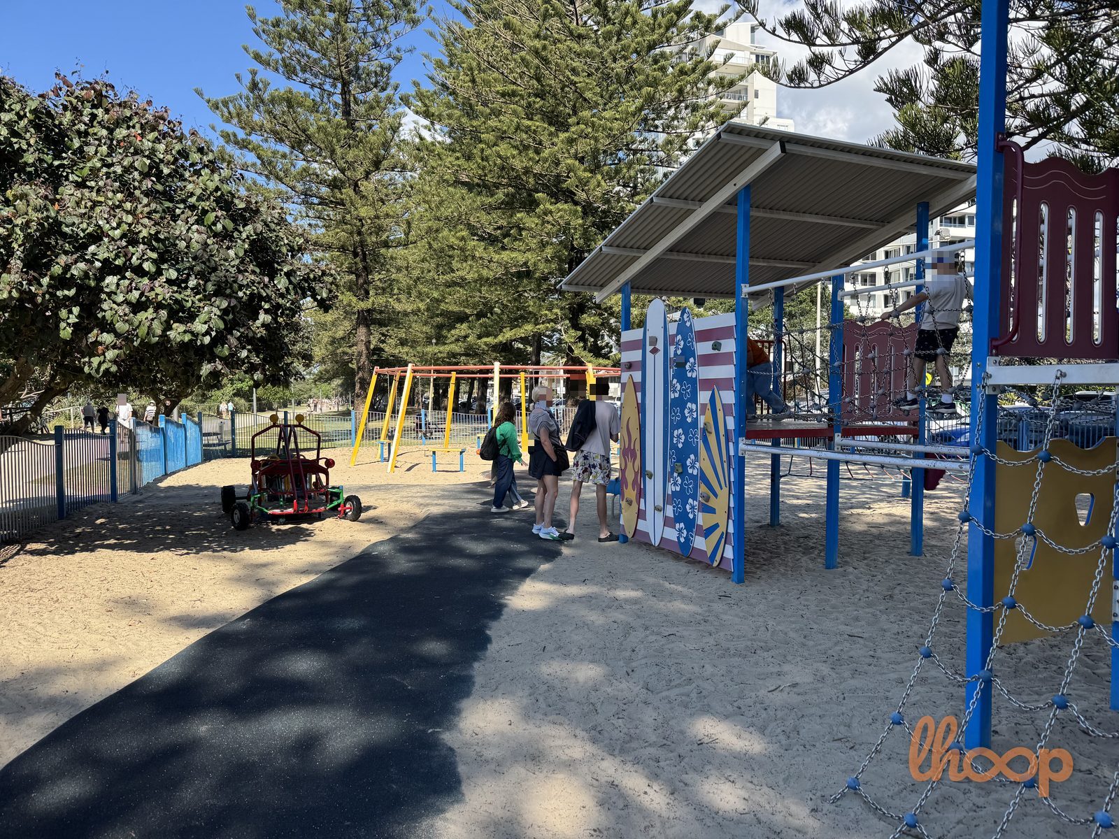 The painted surfboard climbing panels in the foreground, with the swings and the five-person swing frame behind.